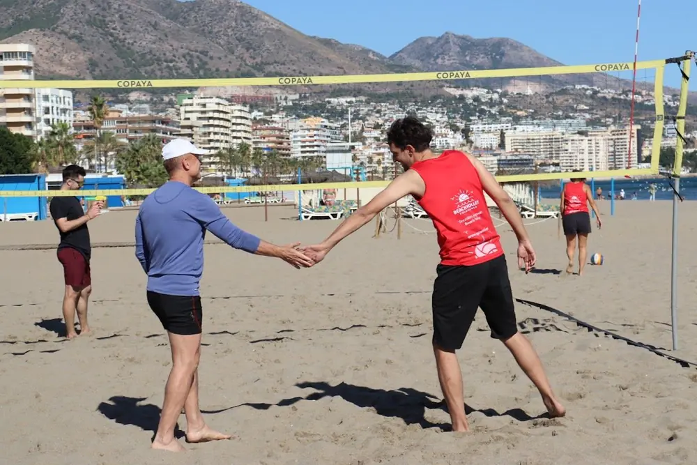 Dos jugadores se dan la mano bajo la red al acabar el partido